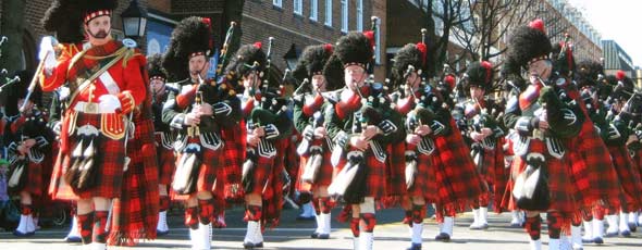 Bagpipers marching in kilts at a festival